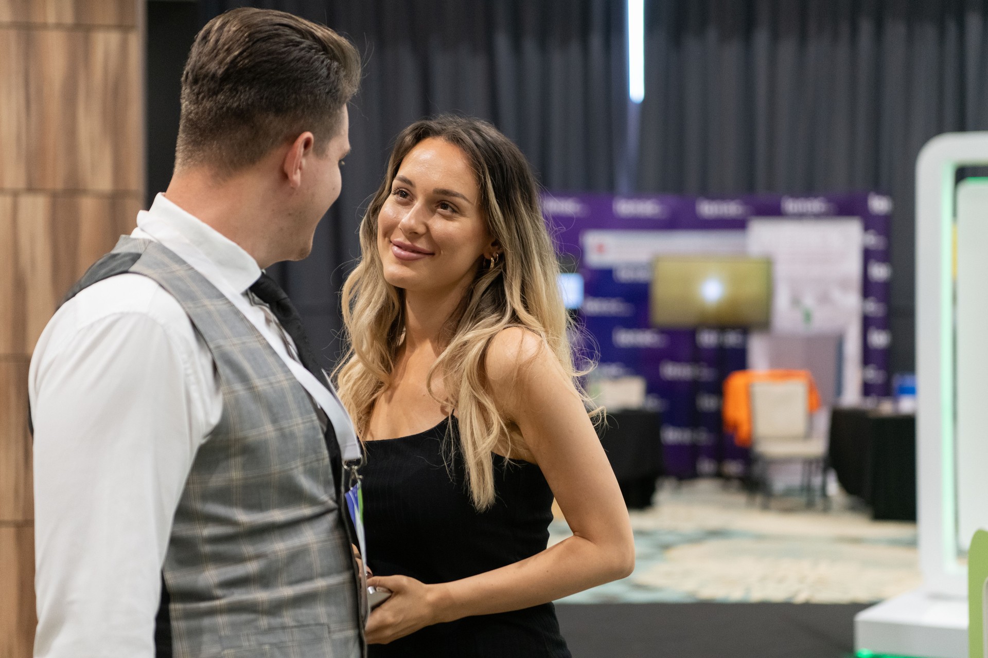 A business couple walking through a trade show, engaging with new ideas and insights to drive their professional growth